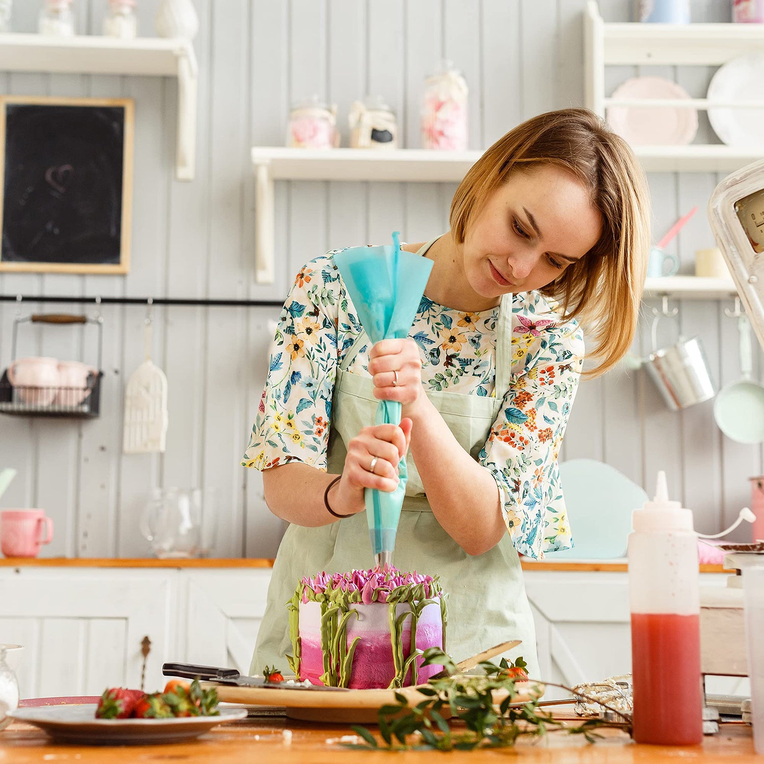 Frau verziert Torte mit Spritzbeutel-Set mit Tüllen - 43-tlg. in heller Küche, Backzubehör und Kuchenverzierung im Einsatz.