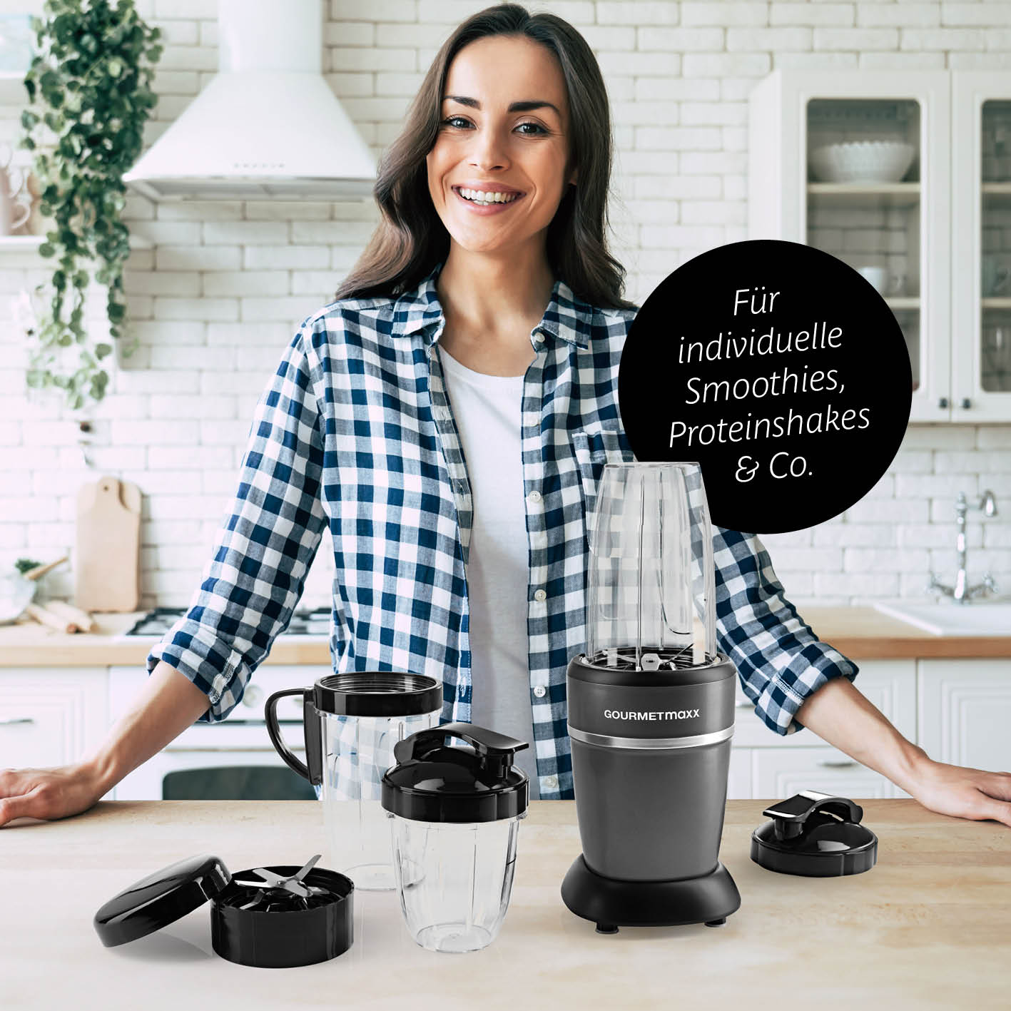 Frau in Küche mit Nutrition Mixer Pro 1.000 mit Zubehörset L - Anthrazit/Schwarz und verschiedenen Mixbechern und Deckeln.