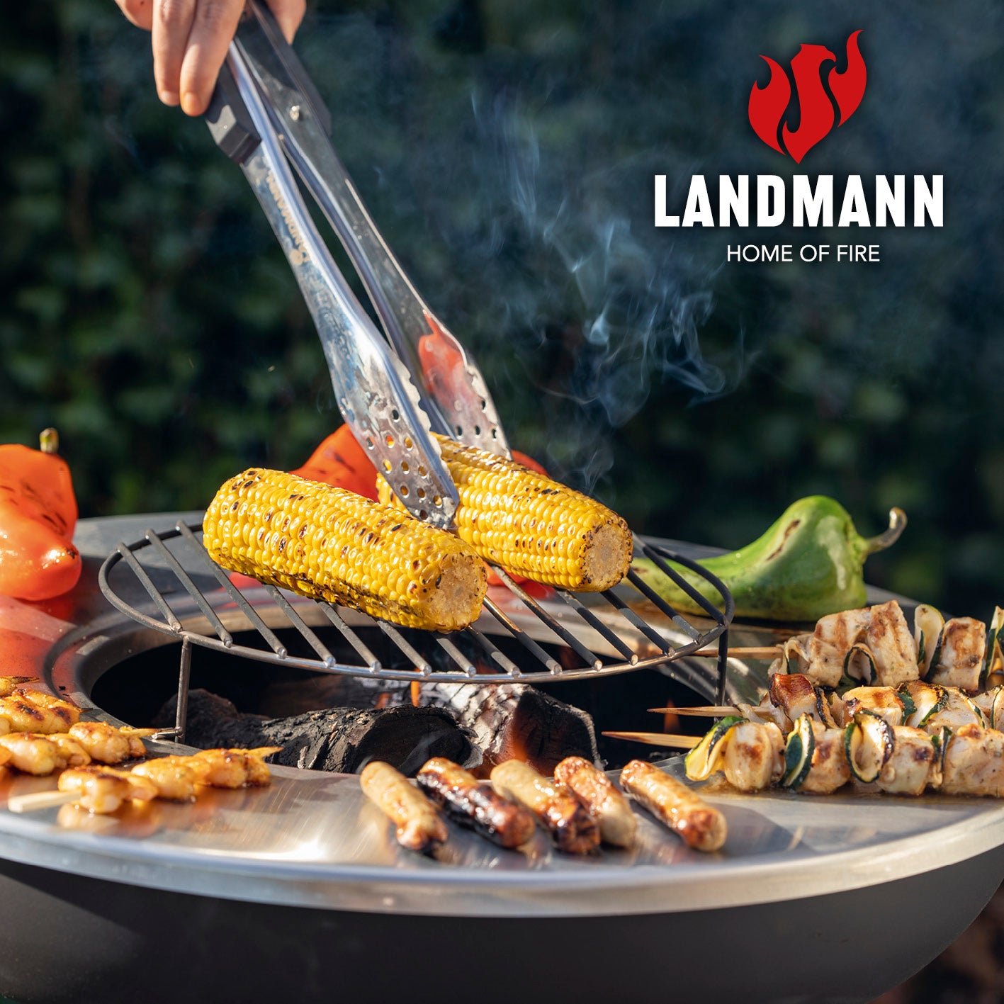 Holzkohlegrill mit Grillrost und Grillplatte mit Grillgut, stabilem Edelstahlgrillplatte und praktischem Kohleschubladensystem.