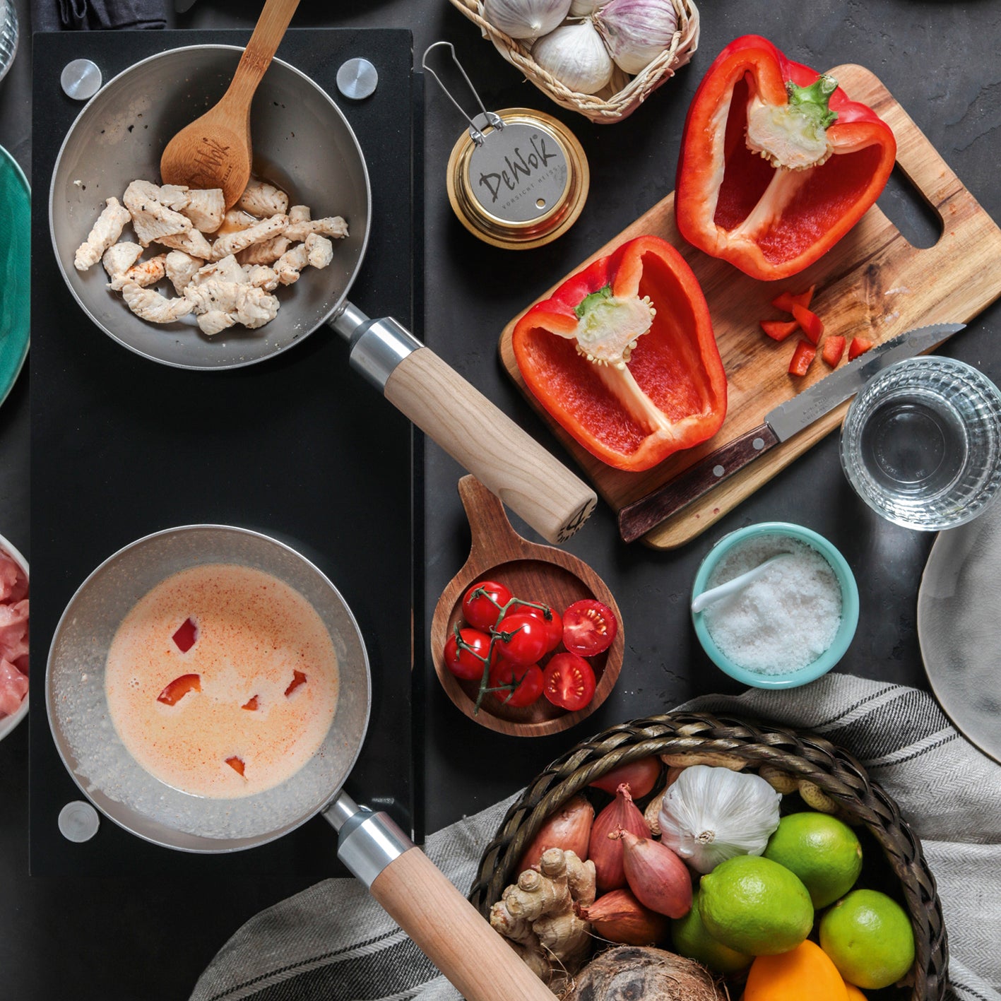 Tisch-Kochset für bis zu 4 Personen - Edelstahl/schwarz mit Pfannen, frischem Gemüse und Kochutensilien für vielseitiges Kochen unterwegs.