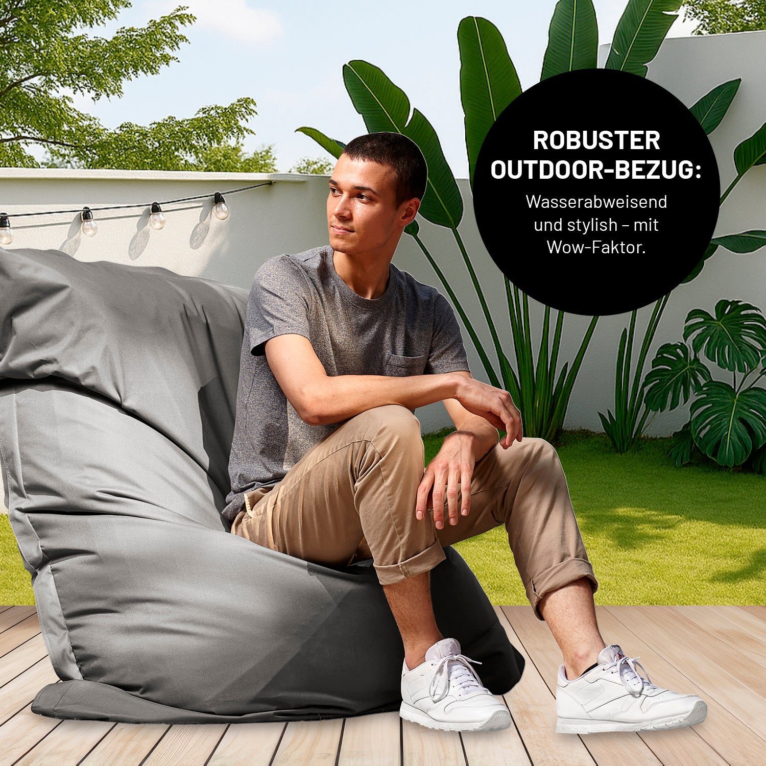 Mann sitzt auf Sitzsack Classic XXL All-in-One Set - 380 L - 140 x 180 cm - Grau mit robustem wasserabweisendem Outdoor-Bezug.