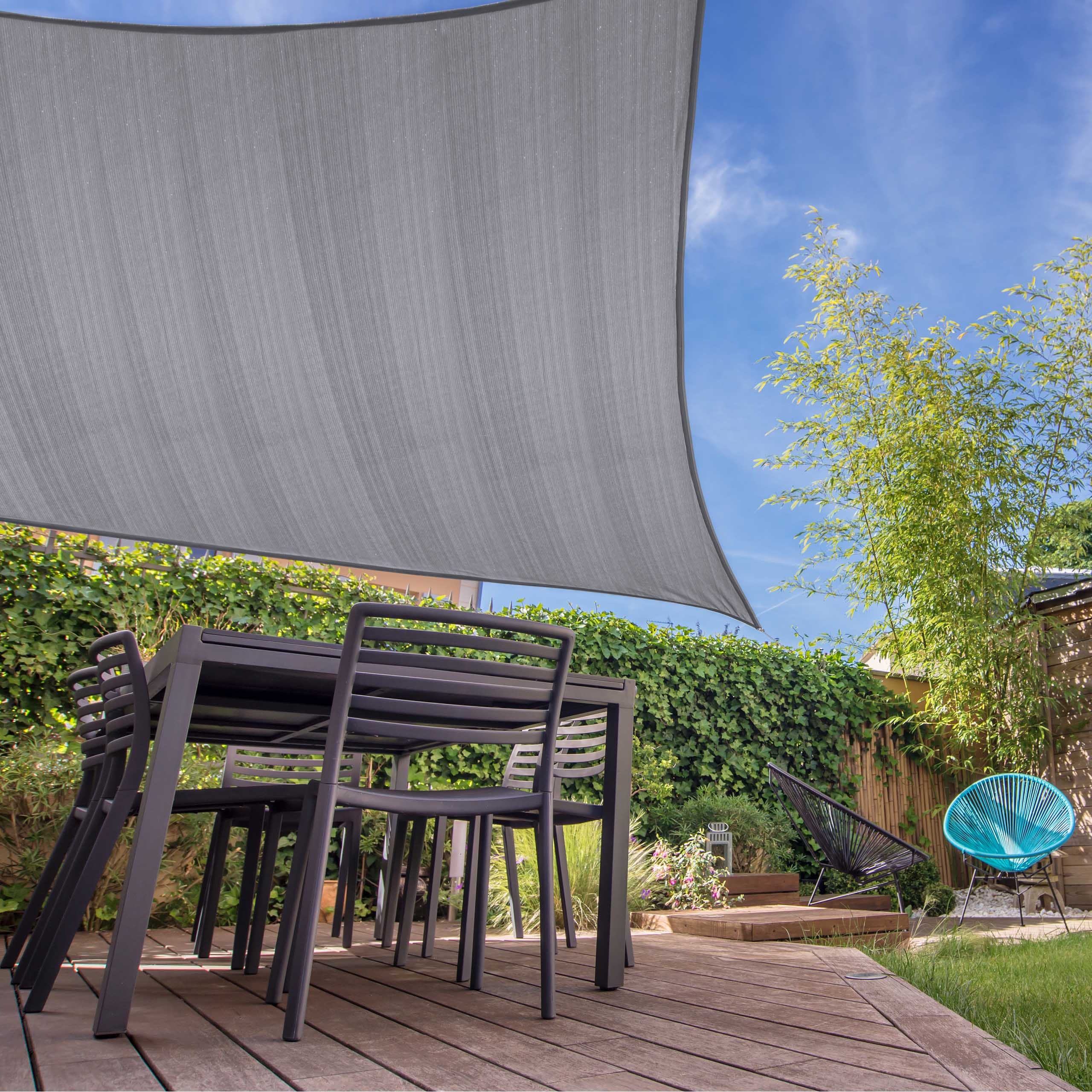 Sonnensegel 100% HDPE mit Stabilisator für UV-Schutz - Rechteck 3 x 4 Meter - Hellgrau über Terrasse mit Gartenmöbeln gespannt.