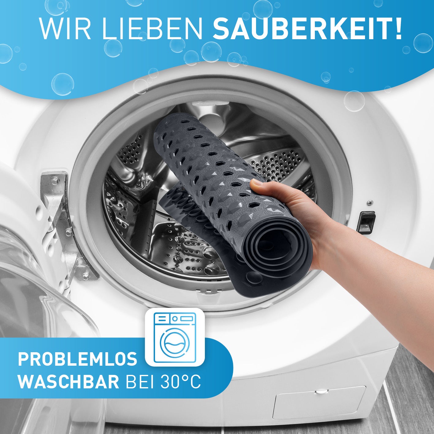 Badewannenmatte 88 x 40 cm – Dunkelgrau wird in Waschmaschine bei 30 °C problemlos gewaschen, zeigt Hand beim Einlegen in Trommel.