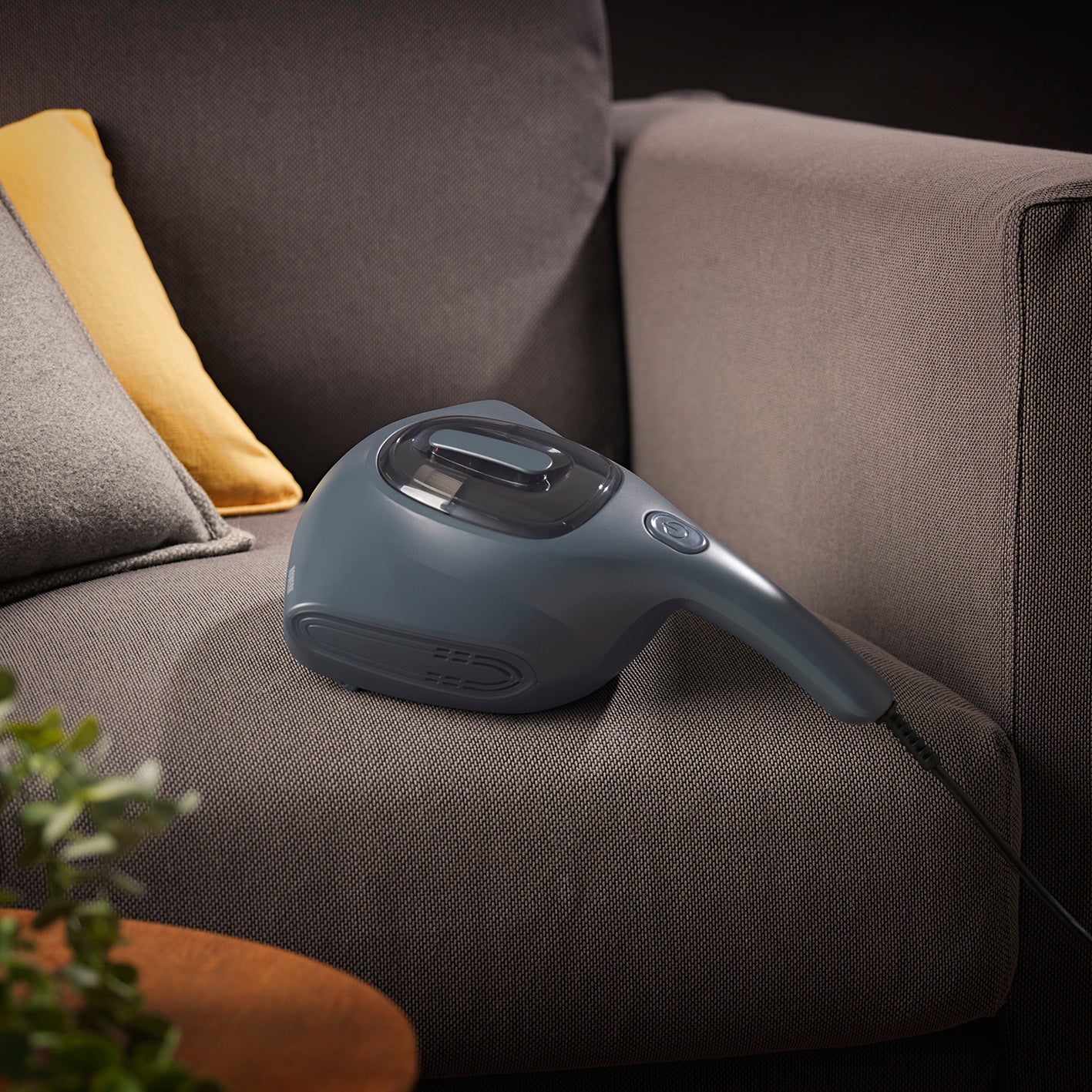 Milbensauger in der Nordic Night Edition auf grauem Sofa, ideal zum Absaugen und Desinfizieren mit UV-C-Licht und HEPA 11-Filter.