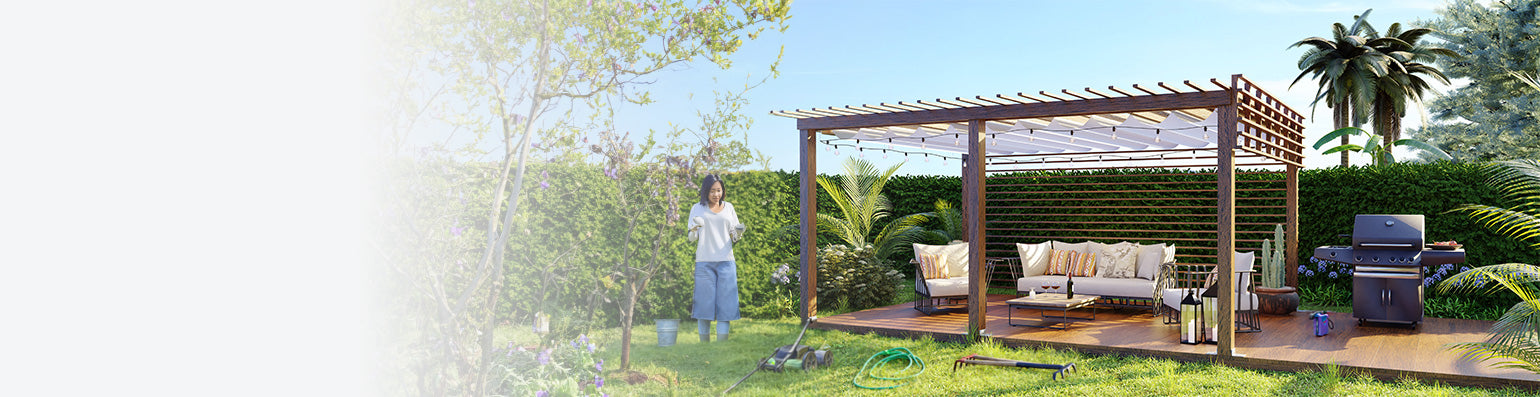 Braune Palisade auf einer terrasse, darunter Gartenmöbel, Solarleuchten und ein Grill. Im Garten eine Frau mit Gartengeräten.