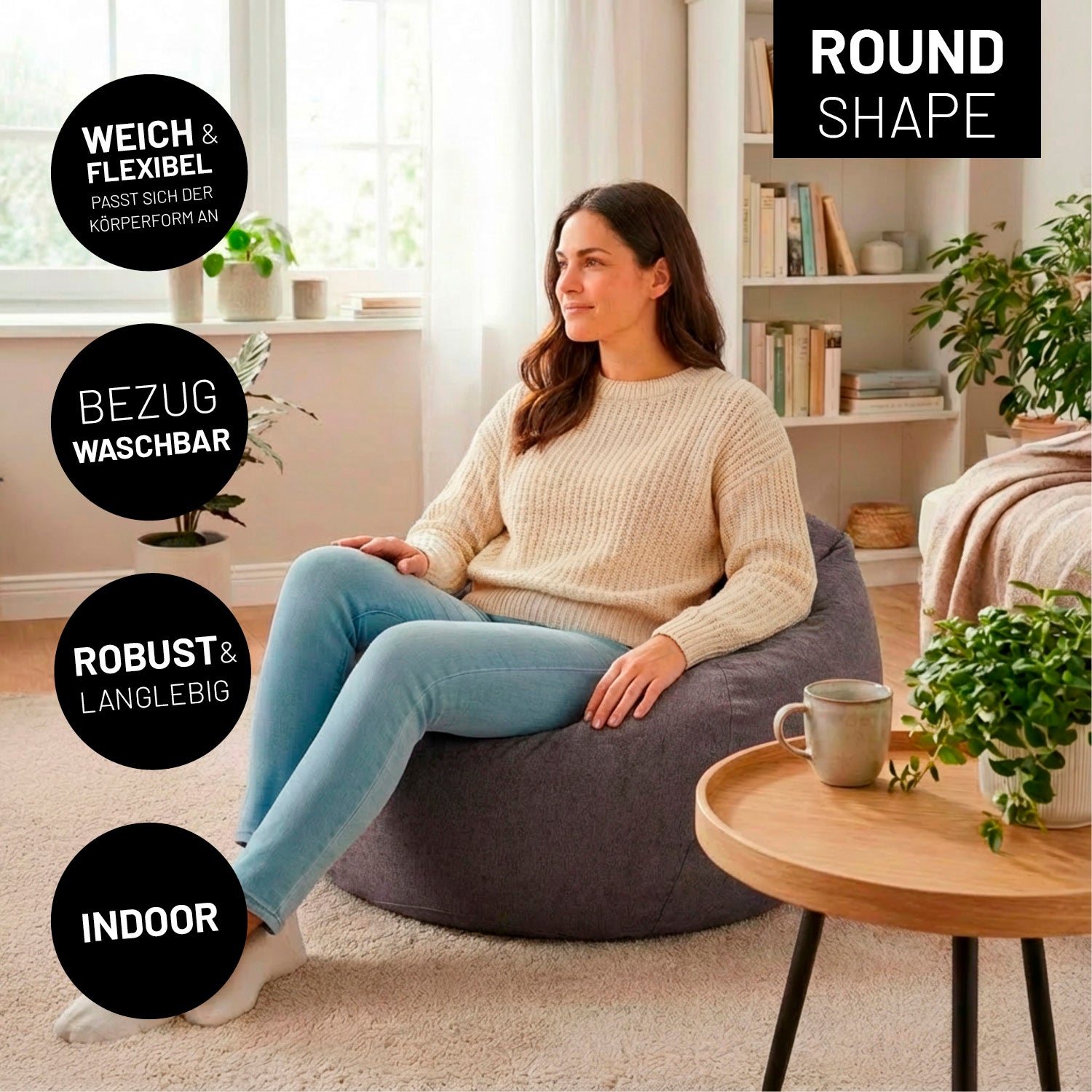 Frau sitzt gemütlich auf dem Comfort Line Sitzsack XL (250 L) - indoor - Dunkelgrau in modernem, hellen Wohnzimmer.