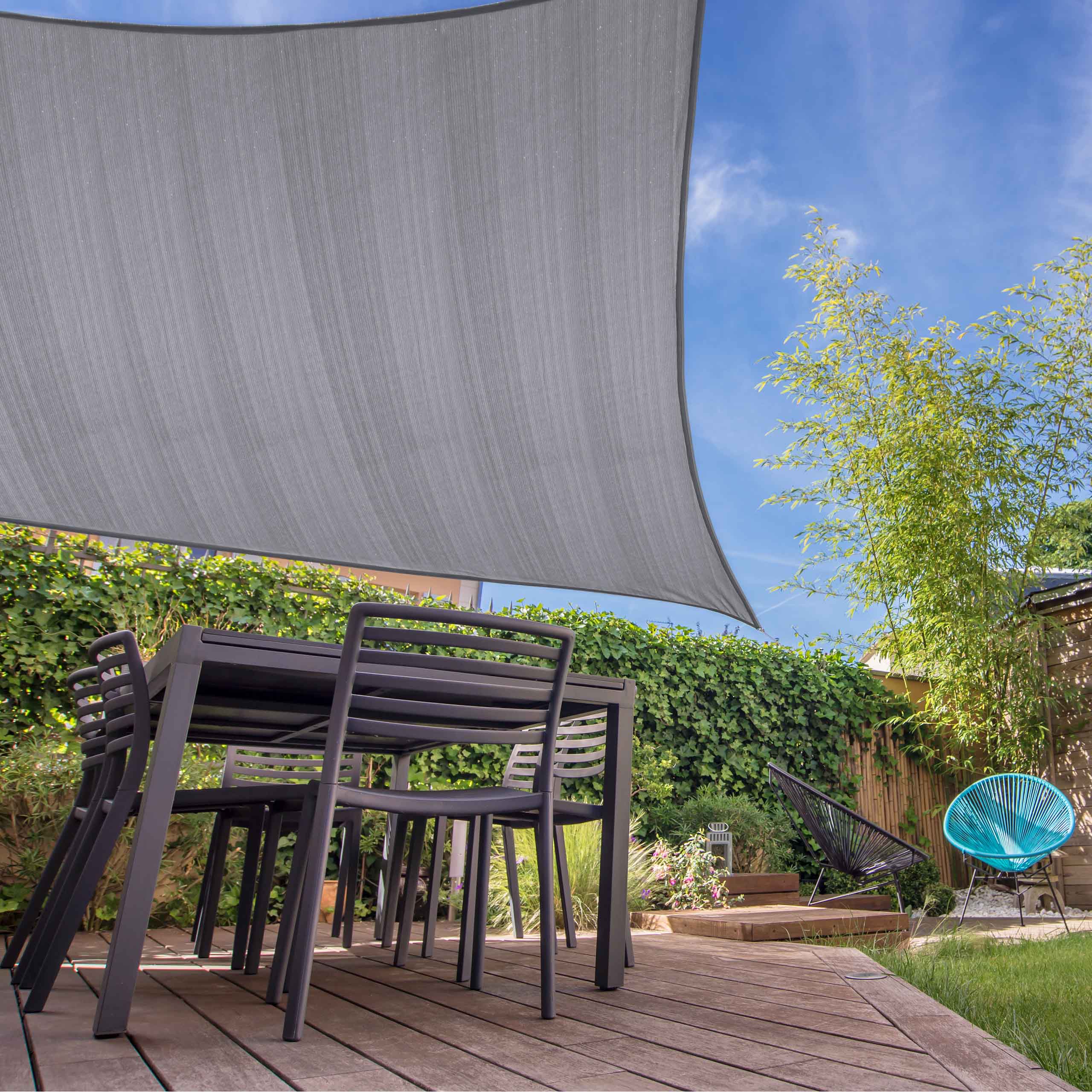 Sonnensegel 100% HDPE mit Stabilisator für UV-Schutz - Rechteck 5 x 7 Meter - Hellgrau über Outdoor-Essbereich auf Holzterrasse gespannt.