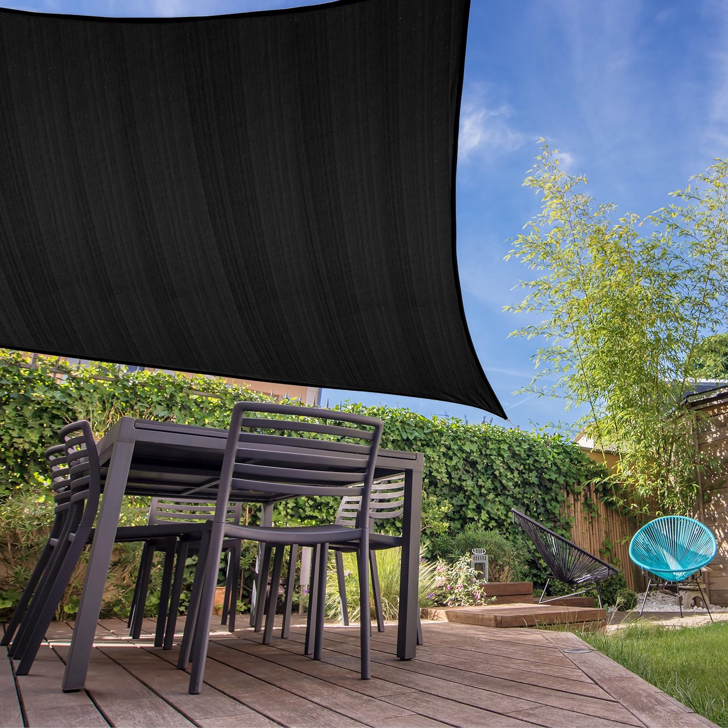 Sonnensegel 100% HDPE mit Stabilisator für UV-Schutz - Rechteck 5 x 7 Meter - Schwarz über Terrasse mit Möbeln und Garten.