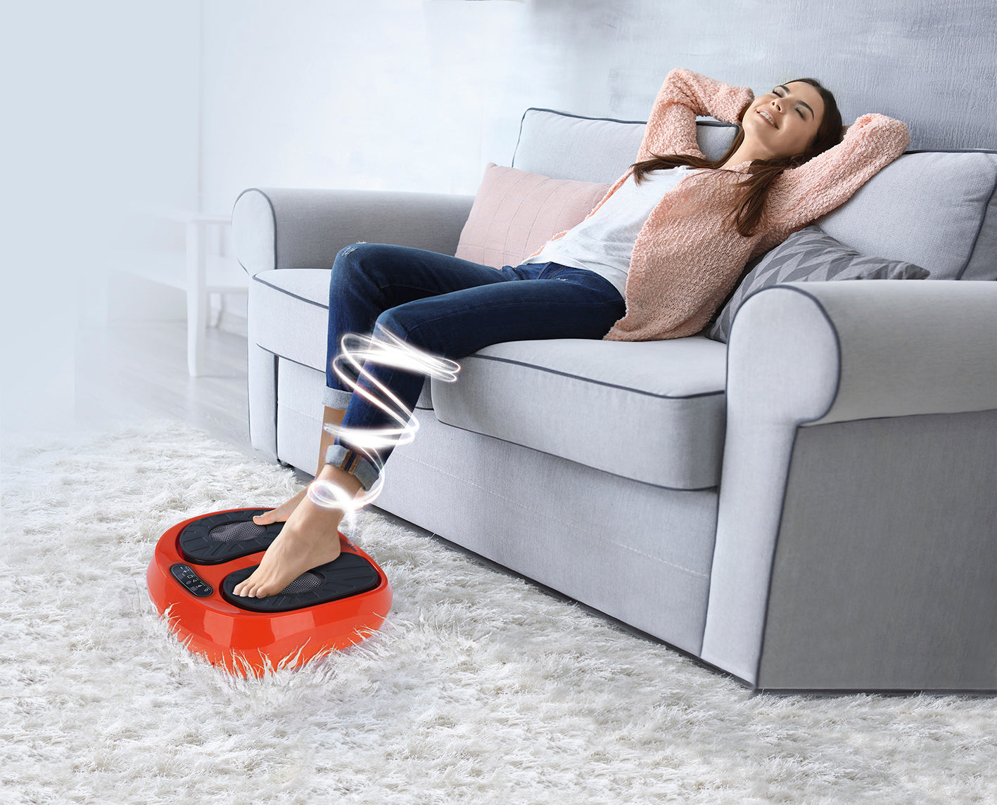 Frau entspannt auf Sofa mit Vibrationsgerät Training & Massage, fördert Durchblutung und Reflexzonenmassage der Füße per Fernbedienung.