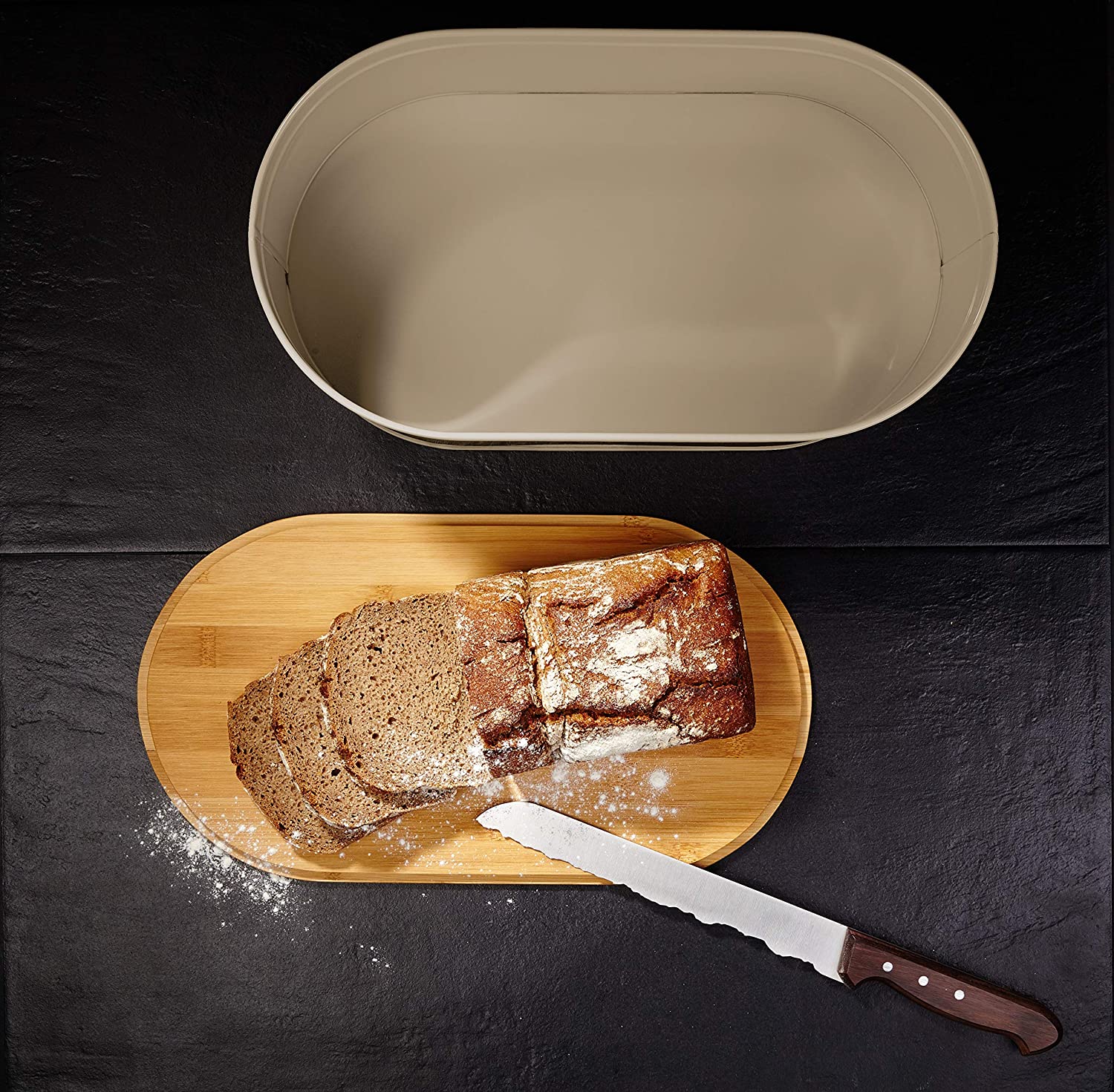 Cuisine Brotkasten aus Metall mit Bambus Deckel - Oval 36 x 20 x 13,8 cm in Grau mit Brotschneidebrett und frisch geschnittenem Brot.