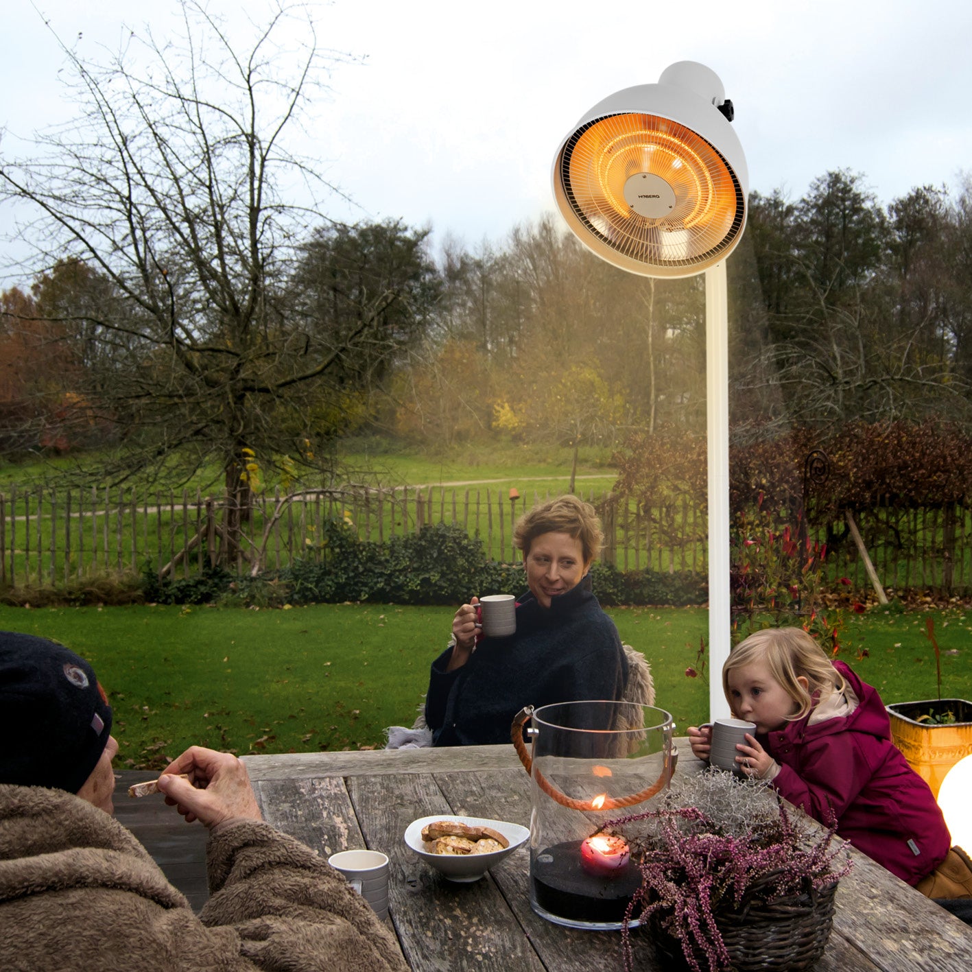 Infrarot-Heizstrahler mit Standfuß im Einsatz im Garten, warmes Licht, komfortable Wärme dank Carbon-Infrarot-Technologie.