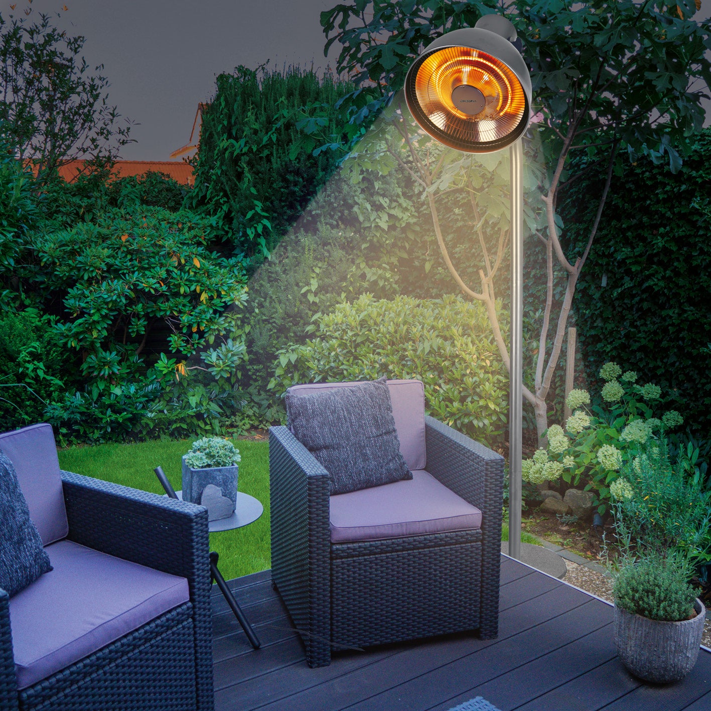 Infrarot-Heizstrahler mit Standfuß im Garten neben Sitzmöbeln, beleuchtet, mit einstellbarem Lampenkopf und warmer Atmosphäre.