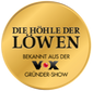 Goldenes Siegel mit der Aufschrift „Die Höhle der Löwen – Bekannt aus der VOX Gründer-Show“, schwarz auf glänzendem Hintergrund.
